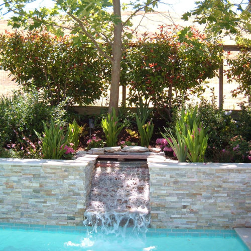 Modern fall between natural stacked stone retaining wall